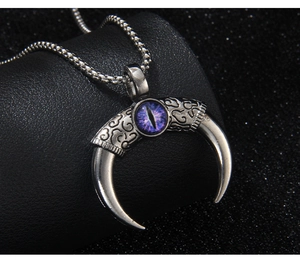 Macro view of gothic devil eye horn pendant with purple eye and vintage engraving