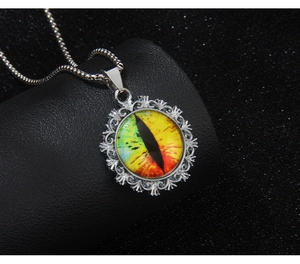 Macro detail of fantasy dragon eye pendant in ornate silver-colored filigree setting
