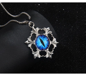 Close-up of silver steel evil eye pendant with blue dragon pupil on box chain