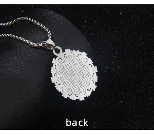 Macro detail of the silver-tone round pendant back featuring intricate hollow textures