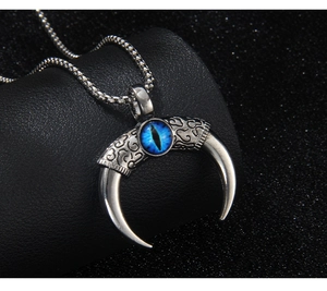 Detail of gothic bull horn pendant with blue evil eye stone and silver scroll engraving