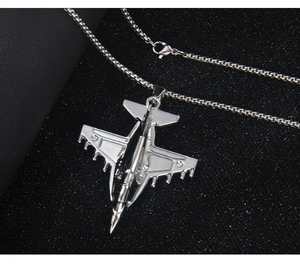 Macro shot of silver stainless steel fighter jet pendant on a classic box chain