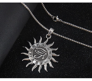 Detail of vintage silver Eye of Horus sun pendant with intricate rune carvings