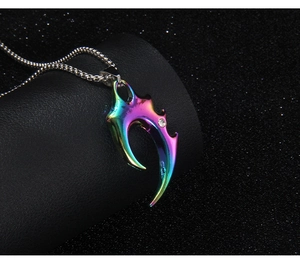 Macro view of a colorful rainbow gradient wolf fang pendant with crystal in stainless steel