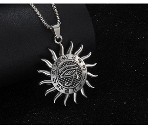 Macro detail of silver Eye of Horus sun pendant with ancient symbols on box chain
