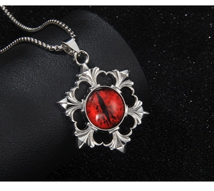 Detailed close-up of a stainless steel evil eye pendant with a red dragon eye stone