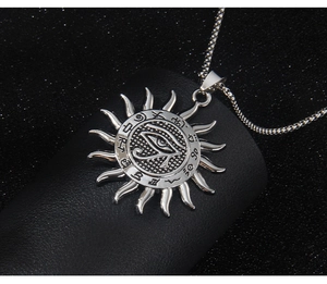 Macro detail of silver Eye of Horus sun pendant on black leather display stand