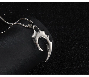 Detailed view of punk wolf tooth pendant in silver steel with a sparkling crystal center