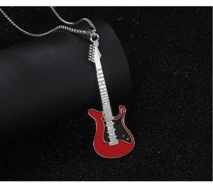 Détail macro du pendentif guitare électrique rouge et noir avec chaîne en acier argenté
