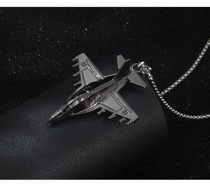 Detailed close-up of a fighter jet pendant with a stainless steel box chain necklace