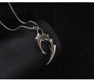 Detail of silver gothic wolf tooth pendant with white crystal on black display