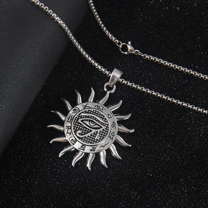 Vintage stainless steel Eye of Horus sun pendant necklace with runes on a black display