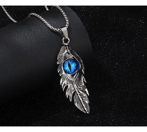 Vue macro du pendentif plume rétro avec œil bleu sur fond noir texturé élégant