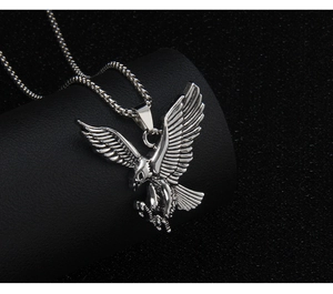 Macro detail of silver stainless steel eagle pendant with intricate feather texture