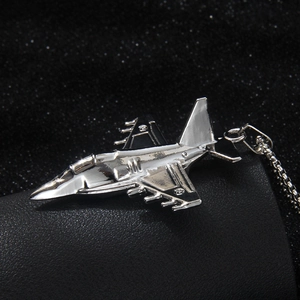 Polished stainless steel fighter jet pendant necklace on a sleek black textured background