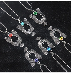 Detail shot of eagle pendants with multi-color evil eye stones on black background