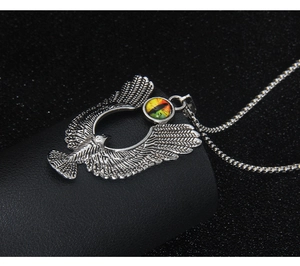 Detailed close-up of vintage eagle pendant with a green dragon eye stone inlay
