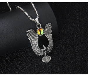 Detailed silver eagle pendant with fine wing texture and green cat eye stone inlay