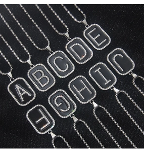 Detailed grid of crystal-encrusted black enamel letter pendants on stainless steel chains