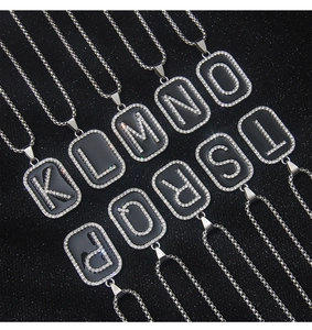 Detailed view of stainless steel rectangular letter pendants with black enamel and zircons