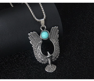 Detailed macro shot of vintage eagle pendant with turquoise bead and stainless steel chain