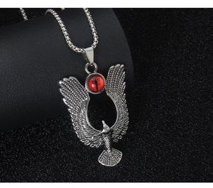 Detail of eagle pendant with red cat-eye stone and textured feathers on silver chain