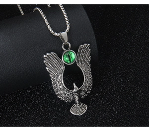 Macro detail of silver eagle pendant with intricate feather texture and green demon eye bead