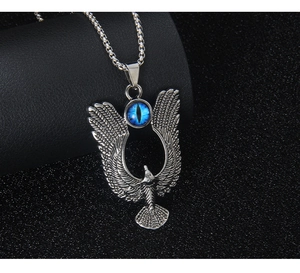 Detailed close-up of eagle pendant with blue gem inlay on a steel box chain
