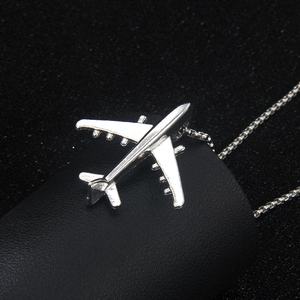 Collar con colgante de avión en acero inoxidable con diseño vintage sobre fondo negro