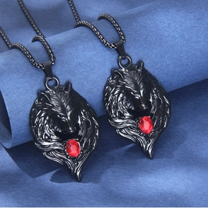 Detailed close-up of two black wolf head necklaces with red crystal eyes and metal chains