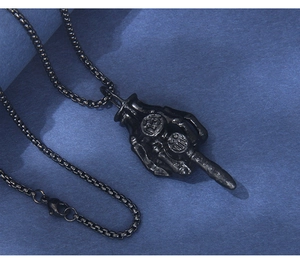 Macro shot of black punk skeleton hand pendant with number 13 on a long chain