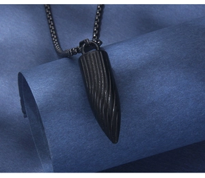 Détail macro du collier pendentif balle noire avec texture spirale et chaîne à billes