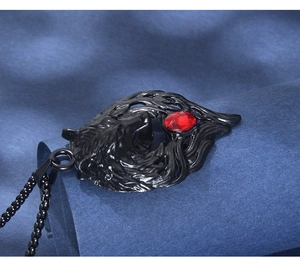 Detail of black stainless steel wolf head pendant with red crystal eyes on beaded chain