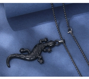 Vista macro dell'anello con ciondolo a forma di lucertola nera in acciaio inossidabile