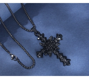 Macro detail of Gothic black rose cross pendant with baroque texture on a matte finish