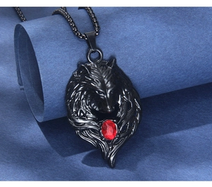 Detailed macro view of black wolf head pendant with a striking red stone and box chain