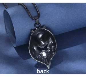 Macro detail of black matte wolf head pendant showing the back structure and white crystal