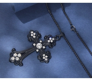 Dettaglio della collana croce gotica nera con strass lucidi e motivi traforati fini
