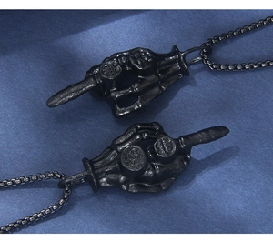 Detailed macro view of gothic matte black skeleton hand middle finger pendant jewelry