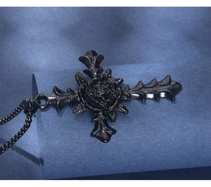 Macro view of gothic black rose cross pendant and beaded chain necklace detail