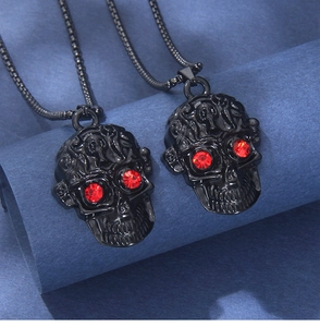 Détail macro du pendentif crâne plaqué noir avec yeux strass rouges et gravure texturée