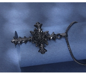 Detail of gothic black rose cross pendant featuring thorny edges and dark beaded chain