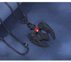 Gros plan du pendentif croix gothique noire avec ailes et pierre précieuse rouge