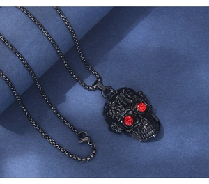 Détail du pendentif crâne punk avec yeux en cristal rouge et texture en relief noir