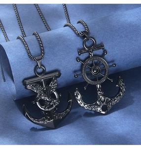 Close-up of black stainless steel anchor pendants with eagle and rudder maritime details