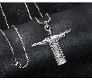 Vue macro du pendentif Christ Rédempteur vintage avec finition antique sur chaîne box