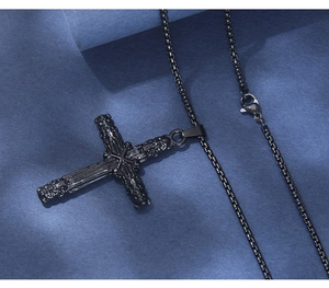 Détail du pendentif croix noire vintage avec relief gothique et chaîne à mailles serrées