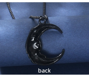 Macro view of the textured back side of a black moon pendant on a blue background