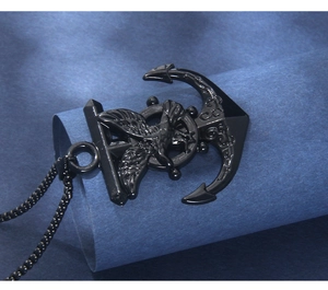 Macro shot of black stainless steel anchor pendant with helm and eagle on beaded chain