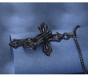 Detail shot of black stainless steel cross pendant with praying hands relief and box chain